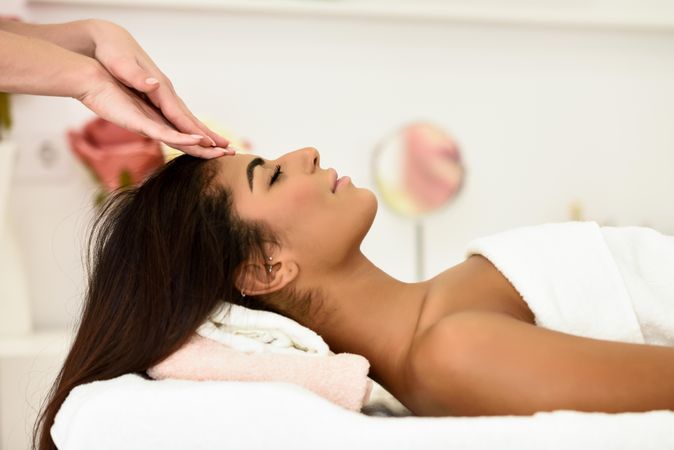 Female having forehead massaged in spa wellness center