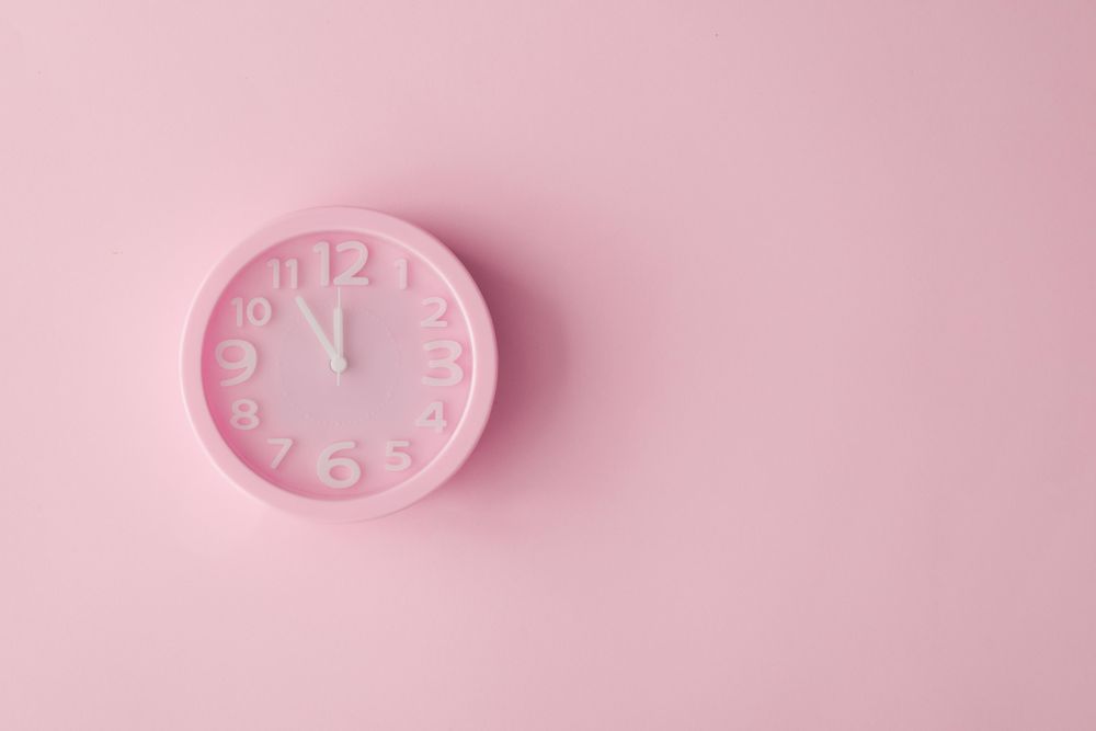 Pastel pink clock on pink painted wall