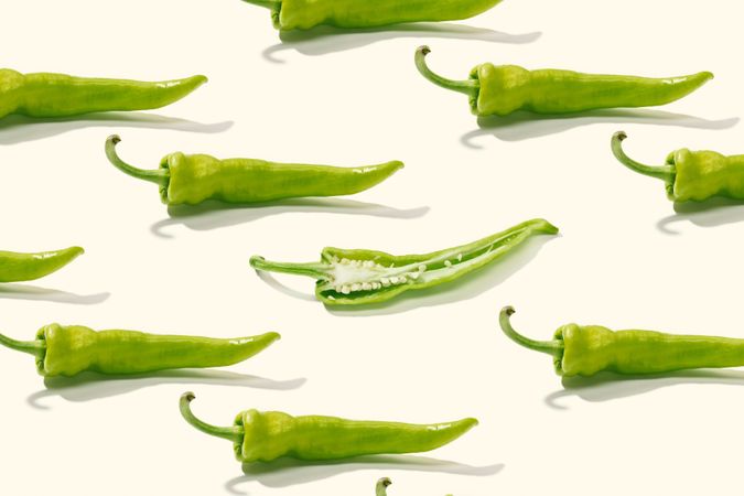 Cut green pepper among rows of whole peppers