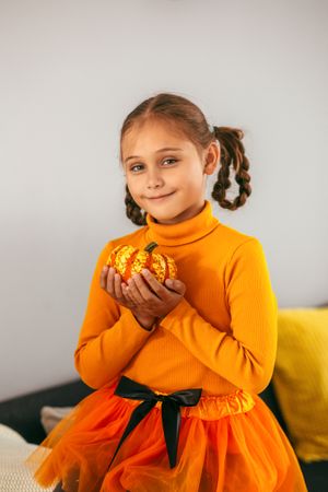 Little Girl Playing With a Pumpkin.