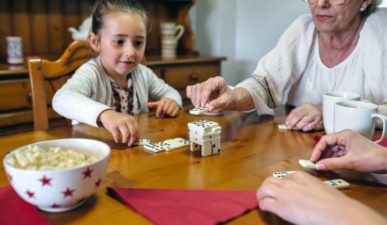 Three female generations playing dominoes