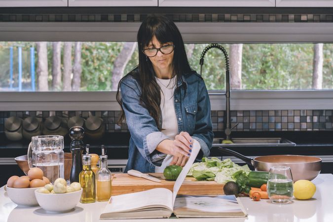woman reading recipe while preparing food in the kitchen.