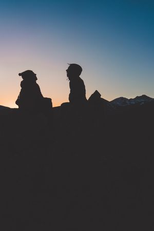 Man and woman enjoying sunset in autumn mountains