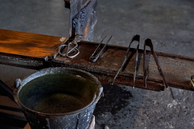 Old metal tools on wooden table in glass factory
