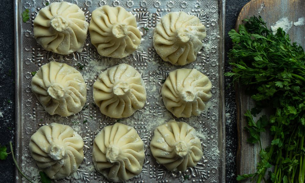 Top view of trey of Georgian khinkali dumplings with cilantro garnish