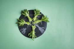 Arugula bundles on a dark round platter