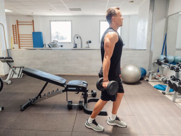 Man doing exercise with dumbbells in gym