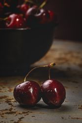 Juicy red cherry in bowl on rustic surface