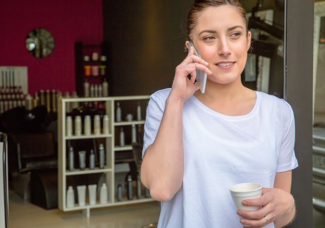 Female hairdresser talking with smartphone in a coffee break