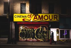 MONTREAL, QUEBEC, CANADA – March 28 2020- at night, a man wearing a mask walking past a closed shop