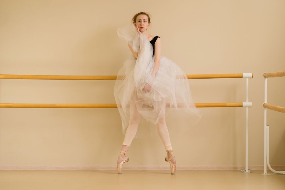 Ballet dancer performs striking pose in studio