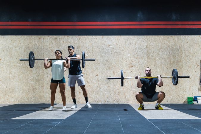 Hispanic sportspeople training with barbells