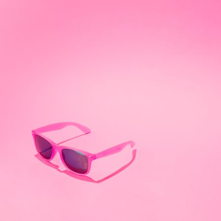 Pink sunglasses on pastel pink background