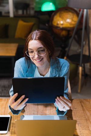 Young smiling businesswoman using tablet in restaurant