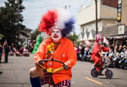 Man dressed as clown on bicycle, in Rhododendron Floral Parade, Florence, Oregon PbY9Xb