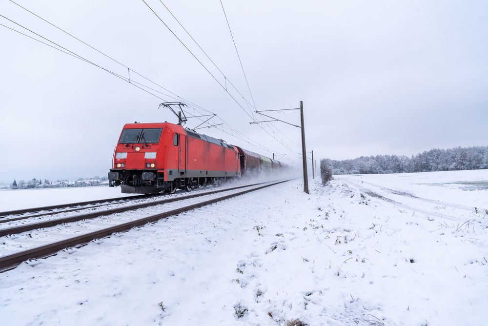 Train traveling through snow, winter scenery in Germany