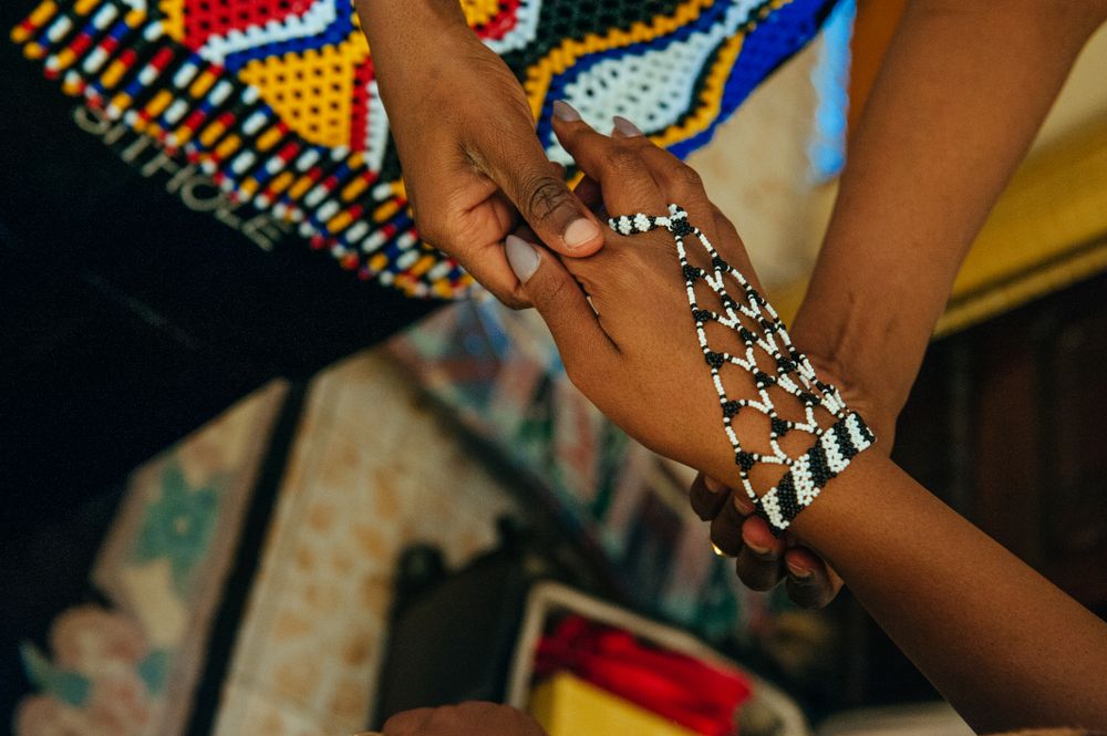 Close up of clasped hand wearing a beaded bracelet