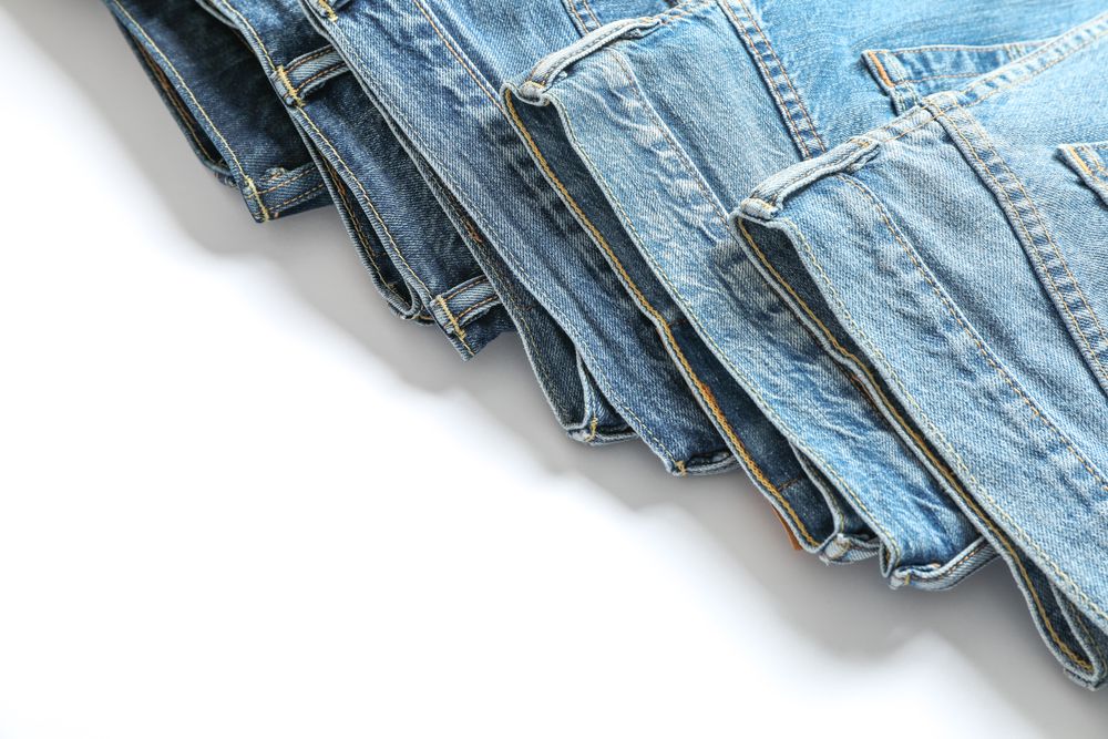 Jeans of different colors isolated on light background, space for text