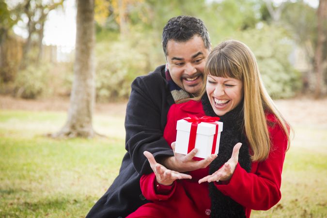 Couple Sharing Christmas or Valentines Day Gift Outside