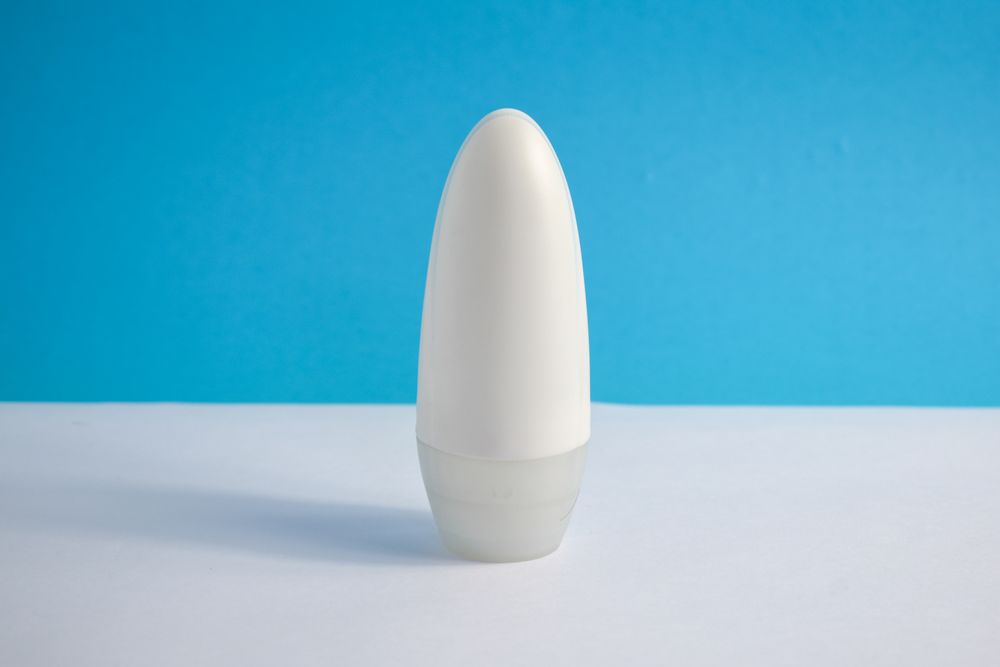 Mock up cosmetic bottle on counter in blue room