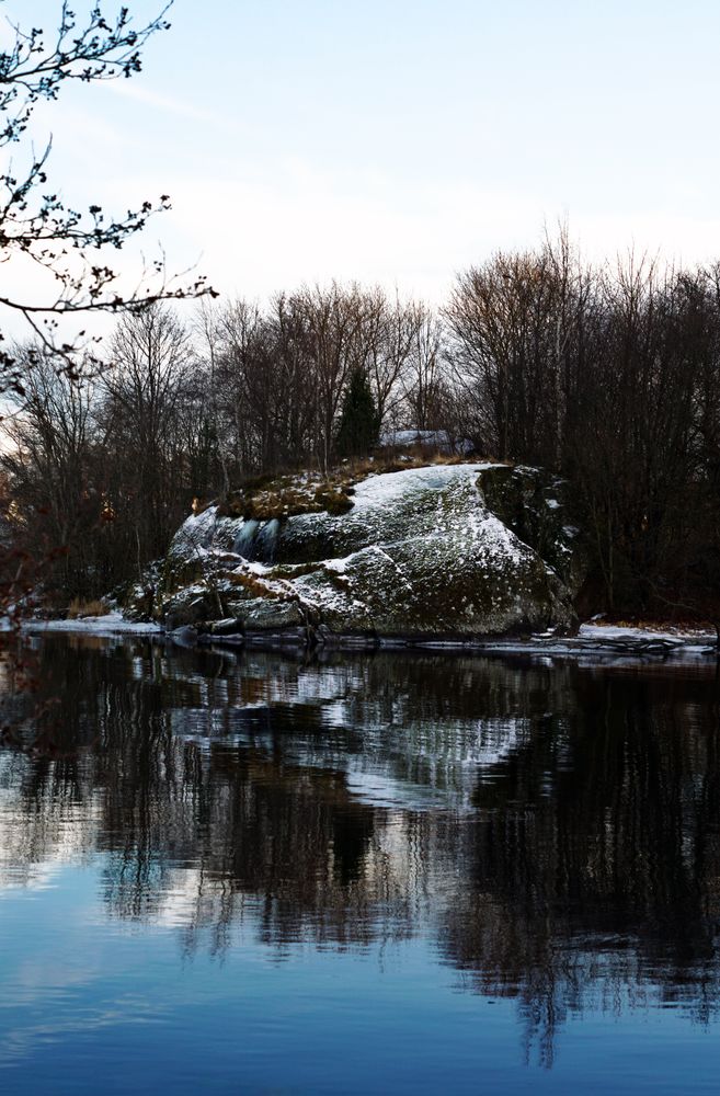 Frosted bank of river with bare trees