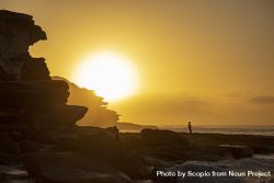 Silhouette of person standing on rock near ocean during sunset 5qQmo5