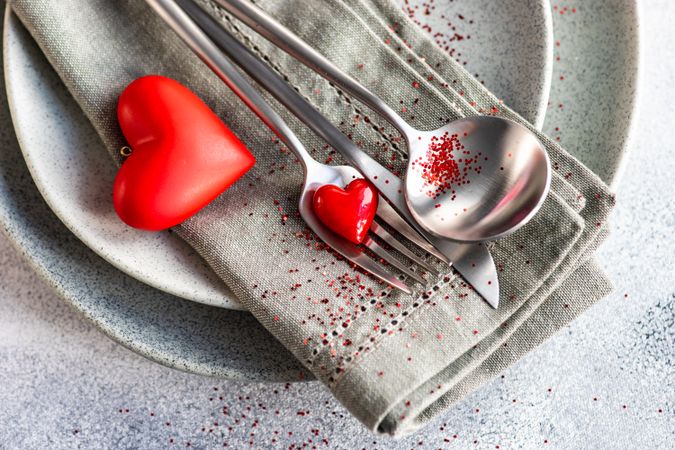 Valentine Day holiday card concept with close up of red glitter on grey plate