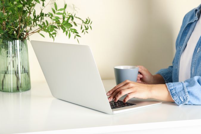 Young woman working on laptop and drink coffee