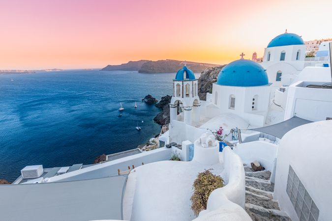 Calm sunset over Santorini with blue domes and town