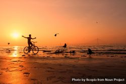Silhouette of boy riding on bike near shore during sunset 5wAeLb