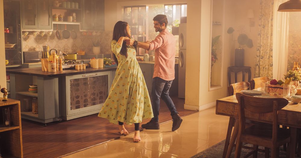 Young Couple Dancing and Having Fun in the Kitchen: Enjoying Each Other's Company and Playfully Moving to Music.