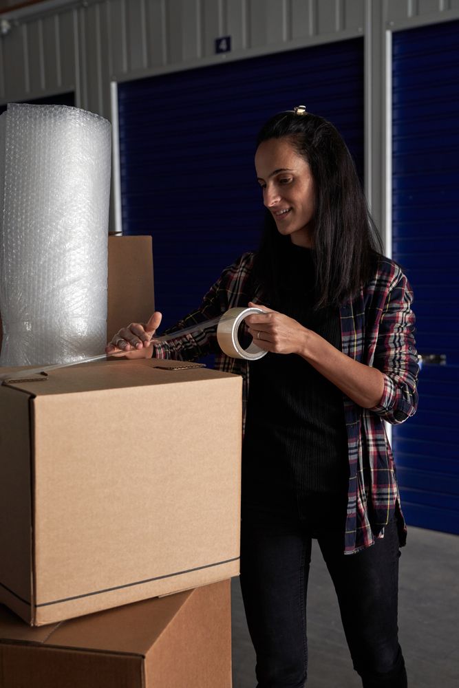 Woman packing belongings with scotch tape