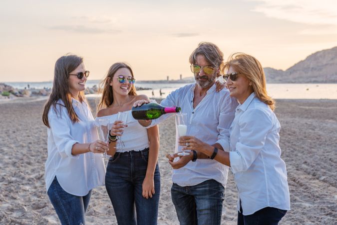 Happy family drinking wine on beach