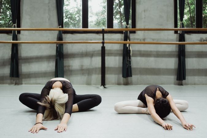 Mature woman and young girl stretching