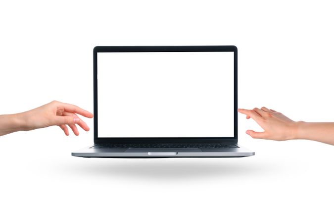 Two hands are reaching out towards a blank laptop screen