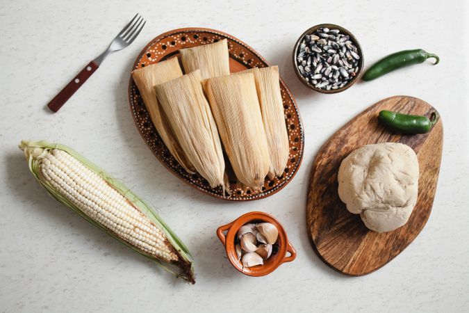 Dough near corn husk and spices for tamales