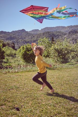 Active boy running with kite