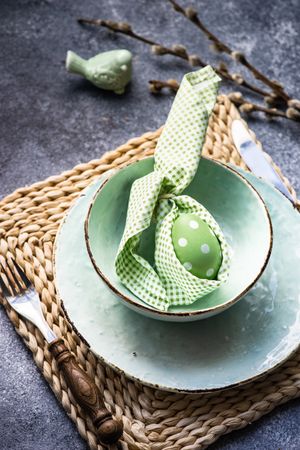 Easter holiday table setting with pastel egg wrapped in bunny napkin