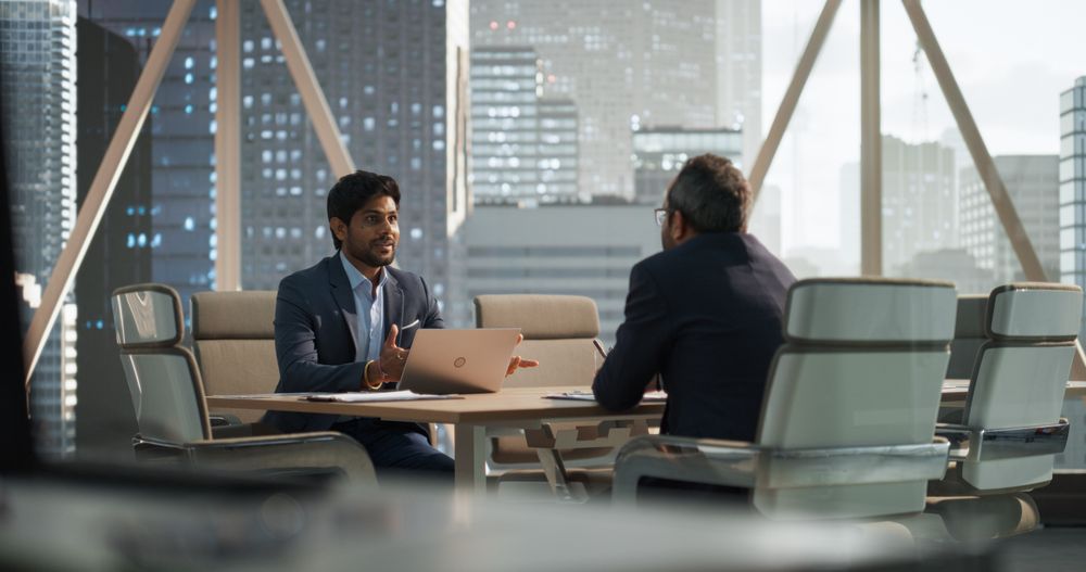 Two Young Indian Businessmen Discussing Investment Opportunities, Strategy, Financing.