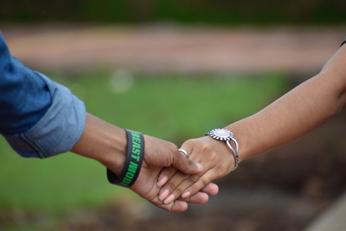 Cropped image of two people holding hands