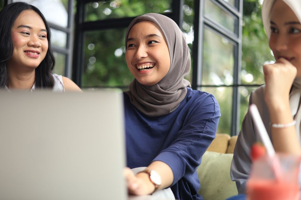 Group of Cheerful and Pretty Asian Female Friends are Hanging Out at a Cafe