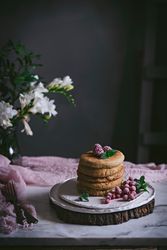 Pile of raspberry pancakes with honey on plate