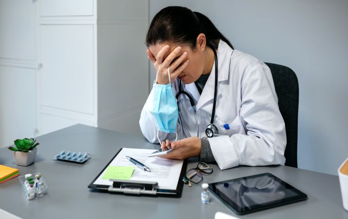 Worried female doctor with hands on face