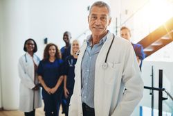 Doctor in lab coat with medical staff