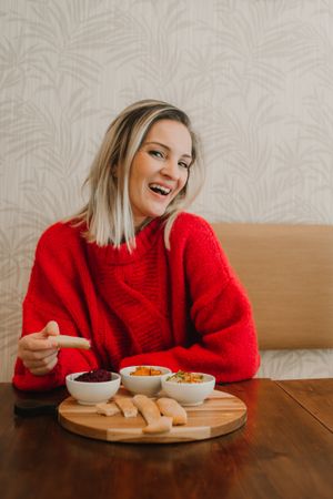 Woman smiling eating assorted food at table