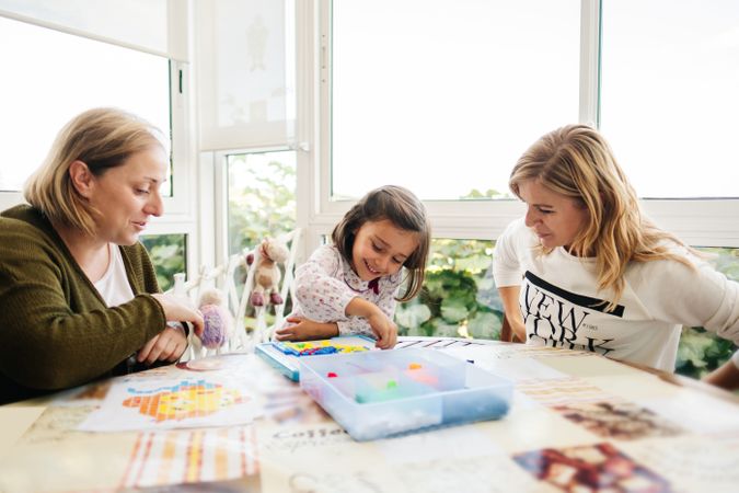 Woman playing board game with daughter and granddaughter