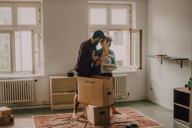Casual couple unpacking boxes in apartment