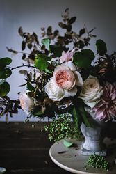 Composition of flowers and plants in vintage vase on board
