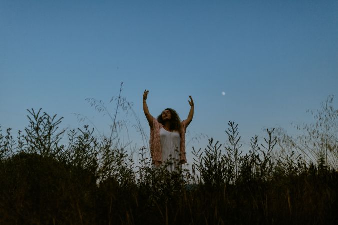 Happy woman raising arms to sky