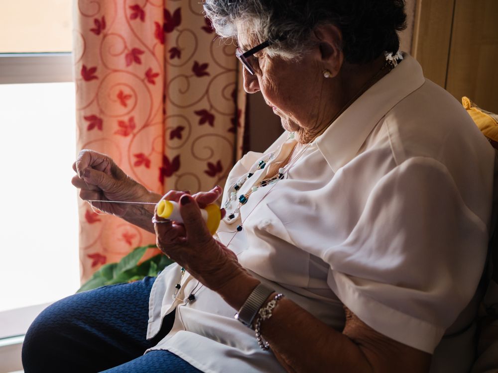 Older woman with threads sitting at home